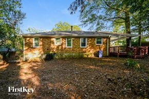 Decatur house for rent - a small brick house with a deck and trees