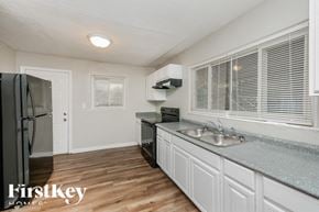 Atlanta house for rent - a kitchen with white cabinets and a sink and a refrigerator