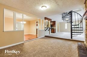 Decatur house for rent - an empty living room with a spiral staircase in a house