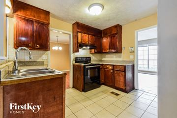 Decatur house for rent - a kitchen with wooden cabinets and a sink and a stove
