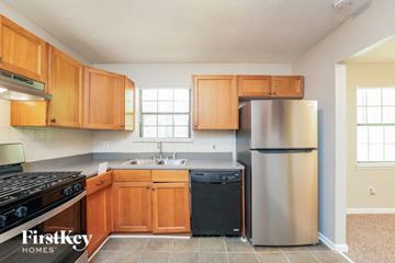 Lithonia house for rent - a kitchen with wooden cabinets and a stainless steel refrigerator