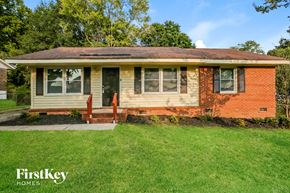 Gastonia house for rent - the front of a brick house with a yard and grass