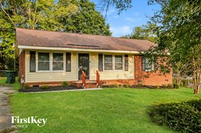 Gastonia house for rent - a small brick house with a lawn and a tree