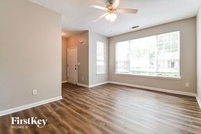 Hampton house for rent - A spacious room with a ceiling fan and wooden flooring.