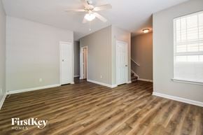 Hampton house for rent - A spacious room with wooden flooring and a ceiling fan.