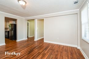 Atlanta house for rent - the living room and dining room of an empty house with wood flooring