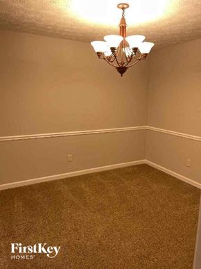 Marietta house for rent - A room with a chandelier and a carpeted floor.