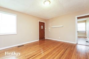 East Point house for rent - the living room of an empty house with wooden floors and a wooden door