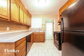 East Point house for rent - a kitchen with black appliances and wooden cabinets