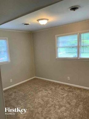 College Park house for rent - a bedroom with a carpeted floor and two windows