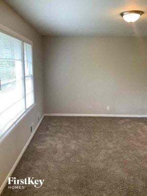 College Park house for rent - an empty living room with a large window and carpet