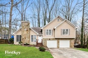 Marietta house for rent - A house with a stone chimney and a garage door.