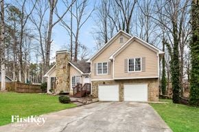 Marietta house for rent - A house with a stone chimney and a garage.