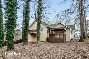 Marietta house for rent - A house with a brown garage is surrounded by trees and has a Firstkey logo.