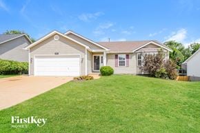 Imperial house for rent - a beige house with a lawn and a white garage door