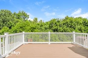 Imperial house for rent - a deck with a white railing and trees in the background