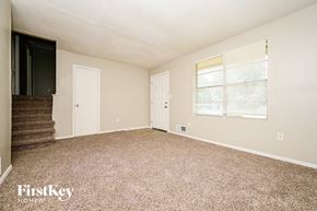 Ellenwood house for rent - A spacious room with a carpeted floor and a window with blinds.