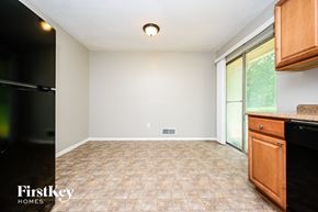Ellenwood house for rent - A kitchen with a black fridge and wooden cabinets.
