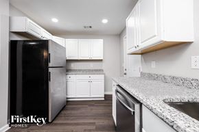Decatur house for rent - a kitchen with white cabinets and granite counter tops and a stainless steel refrigerator