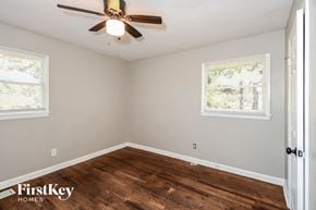 Atlanta house for rent - an empty bedroom with a ceiling fan and wood flooring