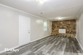 Rex house for rent - an empty room with a stone wall and a white door