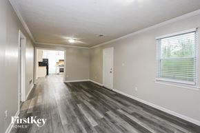 Rex house for rent - an empty living room with wood flooring and a large window