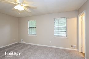 Rex house for rent - a bedroom with a ceiling fan and two windows