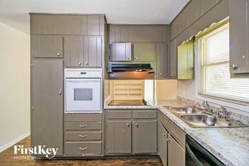 Decatur house for rent - A kitchen with a stove top oven and a sink.
