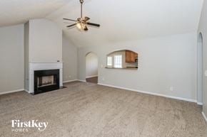 Mcdonough house for rent - an empty living room with a fireplace and a ceiling fan