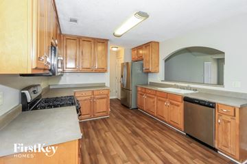 Mcdonough house for rent - a kitchen with wooden cabinets and stainless steel appliances