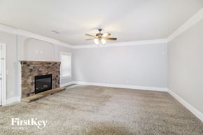 Cumming house for rent - the living room has a stone fireplace and a ceiling fan