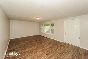 Red Oak house for rent - the living room of an empty house with wood flooring and a white door