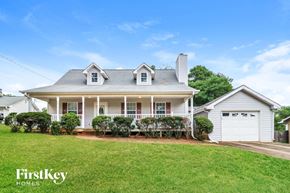 Gainesville house for rent - a white house with a lawn and a white garage door