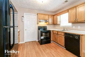 Gainesville house for rent - a kitchen with wooden floors and black appliances