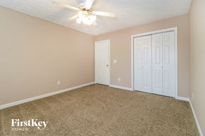 Gainesville house for rent - an empty bedroom with a ceiling fan and two doors