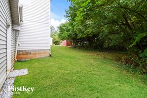 Gainesville house for rent - the backyard of a white house with a yard and trees