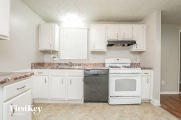 Stone Mountain house for rent - a kitchen with white cabinets and a stove and a microwave