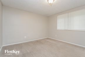 Stone Mountain house for rent - a bedroom with a carpeted floor and a large window