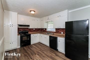 Union City house for rent - a kitchen with black appliances and white cabinets