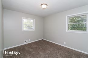 Union City house for rent - a bedroom with a carpeted floor and two windows