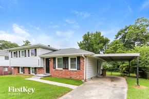 Riverdale house for rent - a white and brick house with a driveway and a covered porch