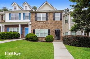 Atlanta house for rent - A brick house with a blue door and a sign that says FirstKey Homes.