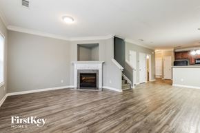 Atlanta house for rent - A spacious living room with a fireplace and wooden flooring.