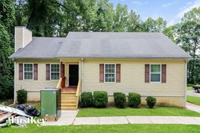Riverdale house for rent - a yellow house with a green refrigerator in the front yard