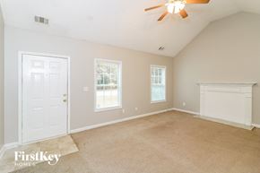 Riverdale house for rent - an empty living room with a ceiling fan and a white door