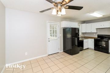 Riverdale house for rent - a kitchen with a black refrigerator and a ceiling fan