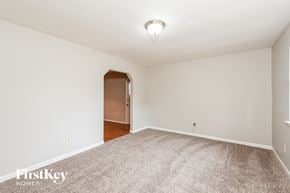 Lithonia house for rent - A room with a carpeted floor and a brown door.