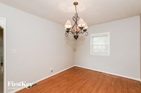 Lithonia house for rent - A room with a wooden floor and a chandelier hanging from the ceiling.