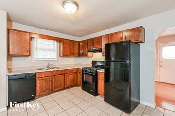 Lithonia house for rent - A kitchen with wooden cabinets and black appliances.