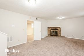 Lithonia house for rent - A spacious living room with a fireplace and carpeted floor.